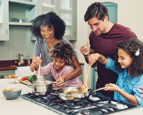 A family cooking inside of a short term rental